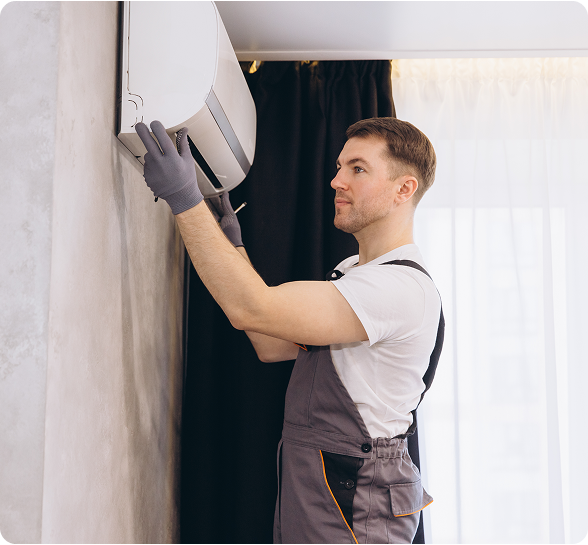 Man installing air conditioning unit indoors.