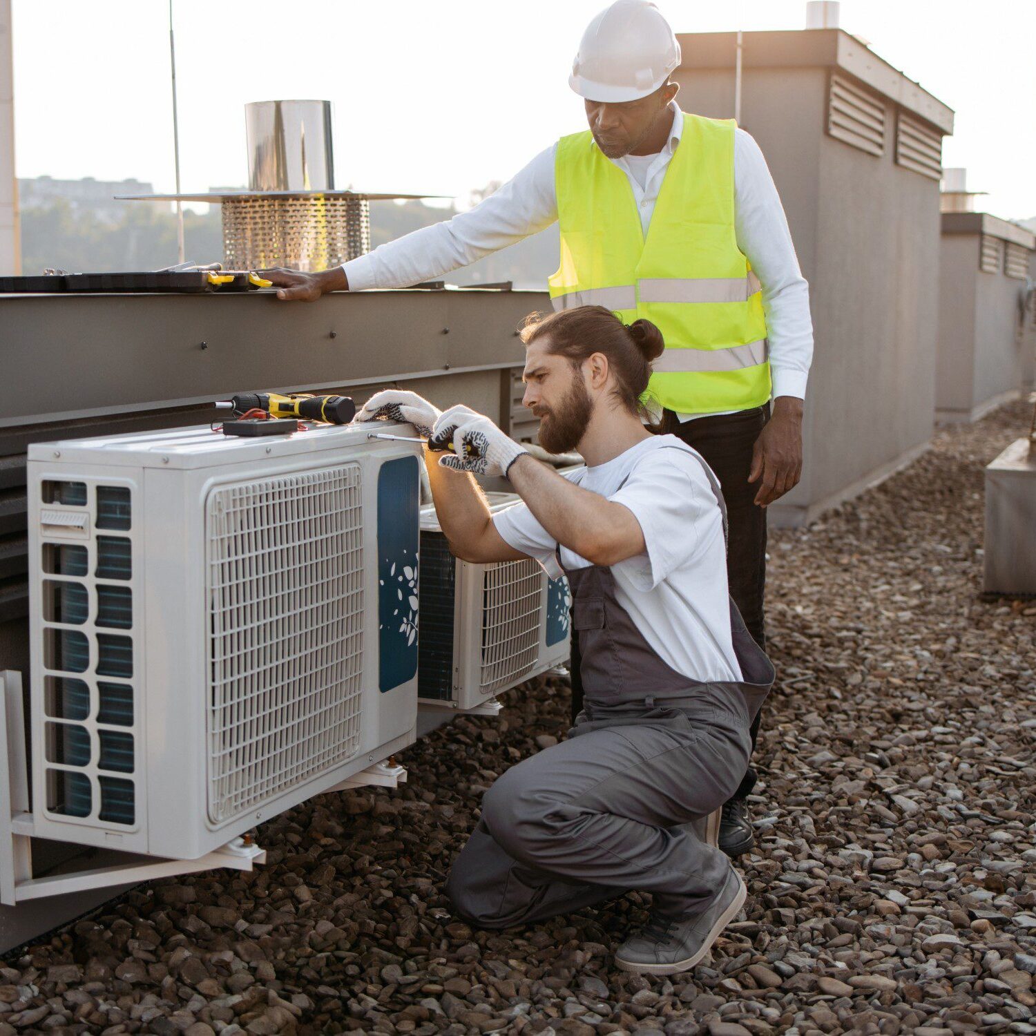 Technicians servicing rooftop air conditioning unit.